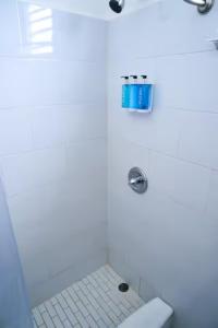 y baño blanco con ducha, aseo y lavamanos. en Digital Nomad San Agustin Apartments en San Juan