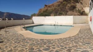 a swimming pool on a patio with a wall at tuGuest Carataunas Apartment Alpujarra V in Carataunas