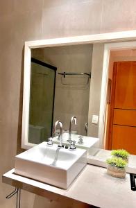 La salle de bains est pourvue de 2 lavabos et d'un grand miroir. dans l'établissement 067 - Rentaqui Flat Apartamento Hampton Jardins, à São Paulo