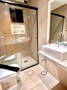La salle de bains est pourvue de toilettes, d'un lavabo et d'une douche. dans l'établissement 067 - Rentaqui Flat Apartamento Hampton Jardins, à São Paulo