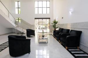- un salon avec des chaises noires et un escalier dans l'établissement 067 - Rentaqui Flat Apartamento Hampton Jardins, à São Paulo