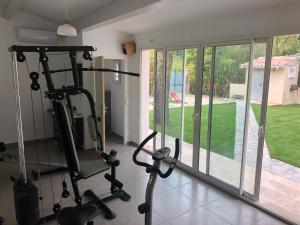 un gimnasio con dos máquinas de correr en una habitación con ventanas en Au milieu des Piboules de Provence. en LʼIsle-sur-la-Sorgue