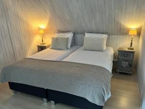 a bedroom with a large bed with two night stands at La Maison du Chevalier in Marat
