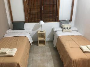 Habitación con 2 camas y mesa con lámpara. en La Casa de Minona en Salta