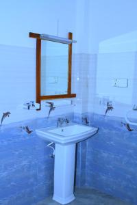 a bathroom with a white sink and a mirror at Hotel 4u Udawalawe in Udawalawe