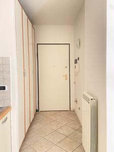 pasillo con puerta blanca y suelo de baldosa en Suite Angeli, a due passi da Assisi, en Santa Maria degli Angeli