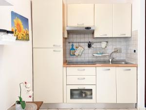 una cocina con armarios blancos y fregadero en Suite Angeli, a due passi da Assisi, en Santa Maria degli Angeli