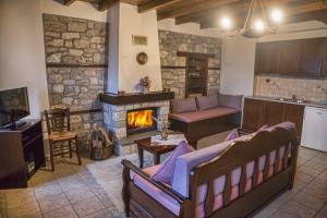 a living room with a couch and a fireplace at T'Asprolithia in Kalyvia Fylaktis