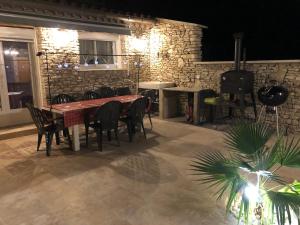 comedor con mesa, sillas y pared de ladrillo en Au milieu des Piboules de Provence. en LʼIsle-sur-la-Sorgue