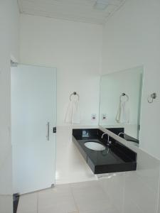 y baño con lavabo y espejo. en Hospedagem Casa Branca Localizada em um bairro nobre de Capitólio, Escarpas do Lago, en Capitólio