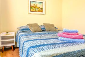 a bedroom with two beds with blue and white sheets at Kitnet com excelente localizacao em Serra Negra SP in Serra Negra