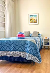 Un dormitorio con una cama con una manta azul. en Kitnet com excelente localizacao em Serra Negra SP, en Serra Negra