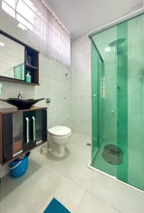 uma casa de banho com um WC e uma cabina de duche em vidro. em Kitnet com excelente localizacao em Serra Negra SP em Serra Negra