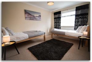 1 dormitorio con 2 camas y ventana en BridgeCity Spacious Bartok House in the Heart of Basingstoke en Worting