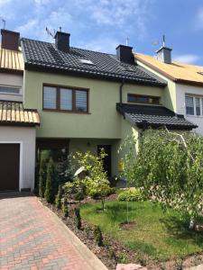 une maison avec un toit carrelé et une allée en briques dans l'établissement Apartament " POD NIEBIESKIM PAGAJEM ", à Mrągowo