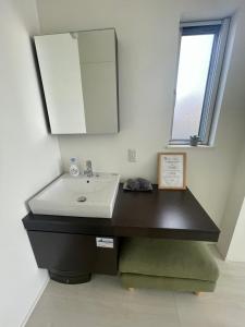 a bathroom with a sink and a mirror at Luxury Villa Saitozaki UMIHOTARU in Fukuoka