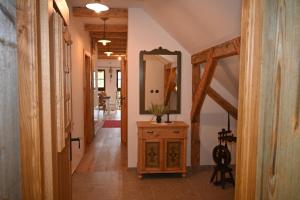 um corredor com um espelho e uma cómoda de madeira em SLOVENIAN HOUSE GOSTECE-Vintage Apartma em Mozirje