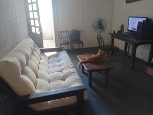 una sala de estar con un sofá grande y un gato sentado en una mesa en La Casa De Seba, en Montevideo