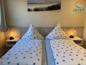 a bedroom with a bed with two pillows on it at Haus Achterhus 215 - Wohnung 11 "Sandkörnchen" in Juist