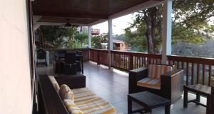 a porch with chairs and tables on a balcony at Villa #4 - Isla Contadora in Contadora +17 photos