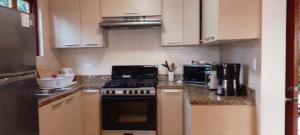 a kitchen with white cabinets and a stove top oven at Villa #4 - Isla Contadora in Contadora