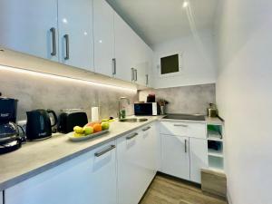 une cuisine blanche avec un bol de fruits sur le comptoir dans l'établissement Direkt am Strand - Playa Patalavaca - Doñana, à Patalavaca