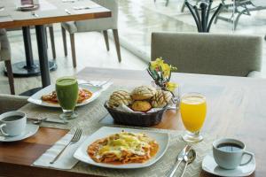 una mesa con platos de comida y bebidas. en Gamma Campeche Malecon, en Campeche