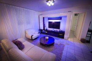 a living room with a white couch and a tv at Locastudio - Grenadine in Sainte-Anne