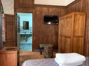 sypialnia z łóżkiem i telewizorem na ścianie w obiekcie Riad Palais Marouane w mieście Meknès