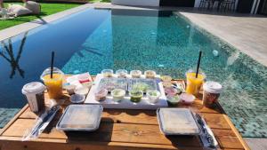 una bandeja de comida en una mesa junto a la piscina en אריאה צימר בוטיק לזוגות Aria en HaZore‘im