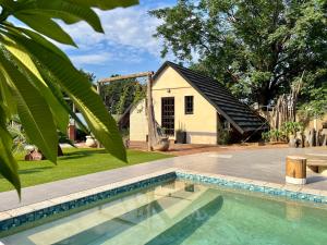 a house with a swimming pool in the yard at Cosy City Cottage in Gaborone