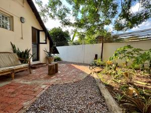 a patio of a house with a bench and a fence at Cosy City Cottage in Gaborone