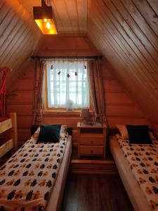 sypialnia na poddaszu z 2 łóżkami i oknem w obiekcie Misia Chata w Zakopanem