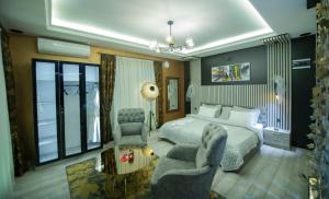 a bedroom with a bed and a couch and a chair at Hotel and Apartments Central City Prishtina in Pristina