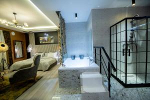 a bathroom with a bath tub and a bedroom at Hotel and Apartments Central City Prishtina in Prishtinë