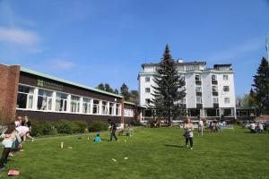eine Gruppe von Personen auf einem Feld vor einem Gebäude in der Unterkunft Hostel Oslofjord in Stabekk