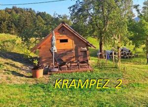 una pequeña casa con un columpio en el césped en Krampez en Kobarid