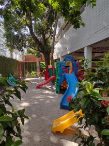un parque infantil con un tobogán azul y amarillo en Boa viagem vista mar 3qts, en Recife