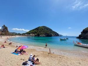 a group of people sitting on a beach at Villa Ettore in Gardeládes