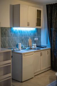 a kitchen with white cabinets and a sink at Stan na dan CENTRAL Uzice in Užice +8 photos