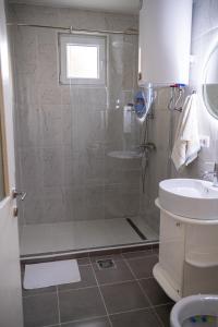 ein Bad mit einer Dusche und einem Waschbecken in der Unterkunft Stan na dan CENTRAL Uzice in Užice