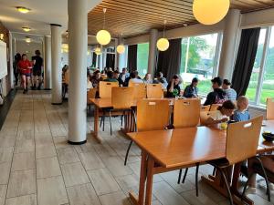 a group of people sitting at tables in a restaurant at Hostel Oslofjord in Stabekk