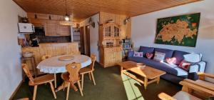 a living room with a blue couch and a table at Edelweiss 6 in Champoussin
