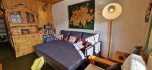 een slaapkamer met een blauw bed met kussens erop bij Edelweiss 6 in Champoussin