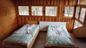 a room with two beds in a cabin with windows at Guest House Mala Prica in Živinice
