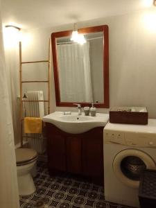 a bathroom with a sink and a toilet and a mirror at Nostos-Δωρεάν κλειστός χώρος στάθμευσης in Volos