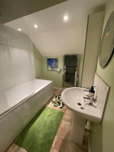 ein Badezimmer mit einer Badewanne, einem Waschbecken und einer Badewanne in der Unterkunft Escape to a Cosy Country Barn: Discover the Charm of Rustic Living 