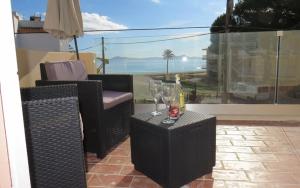 un patio con 2 sillas y una mesa con copas de vino en SEASIDE HOUSES, en Alcudia