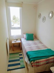 1 dormitorio con 2 camas y ventana en Departamento Lomas de Papudo 2, en Valparaíso