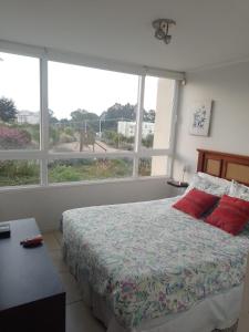 1 dormitorio con cama y ventana grande en Departamento Lomas de Papudo 2, en Valparaíso